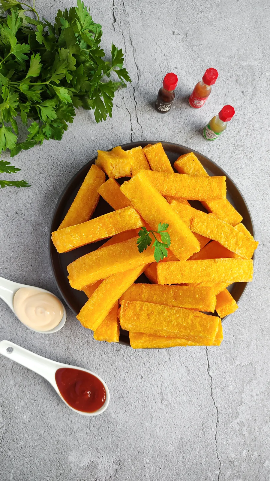 Polenta palito da Momil Alimentos servida em prato com molhos