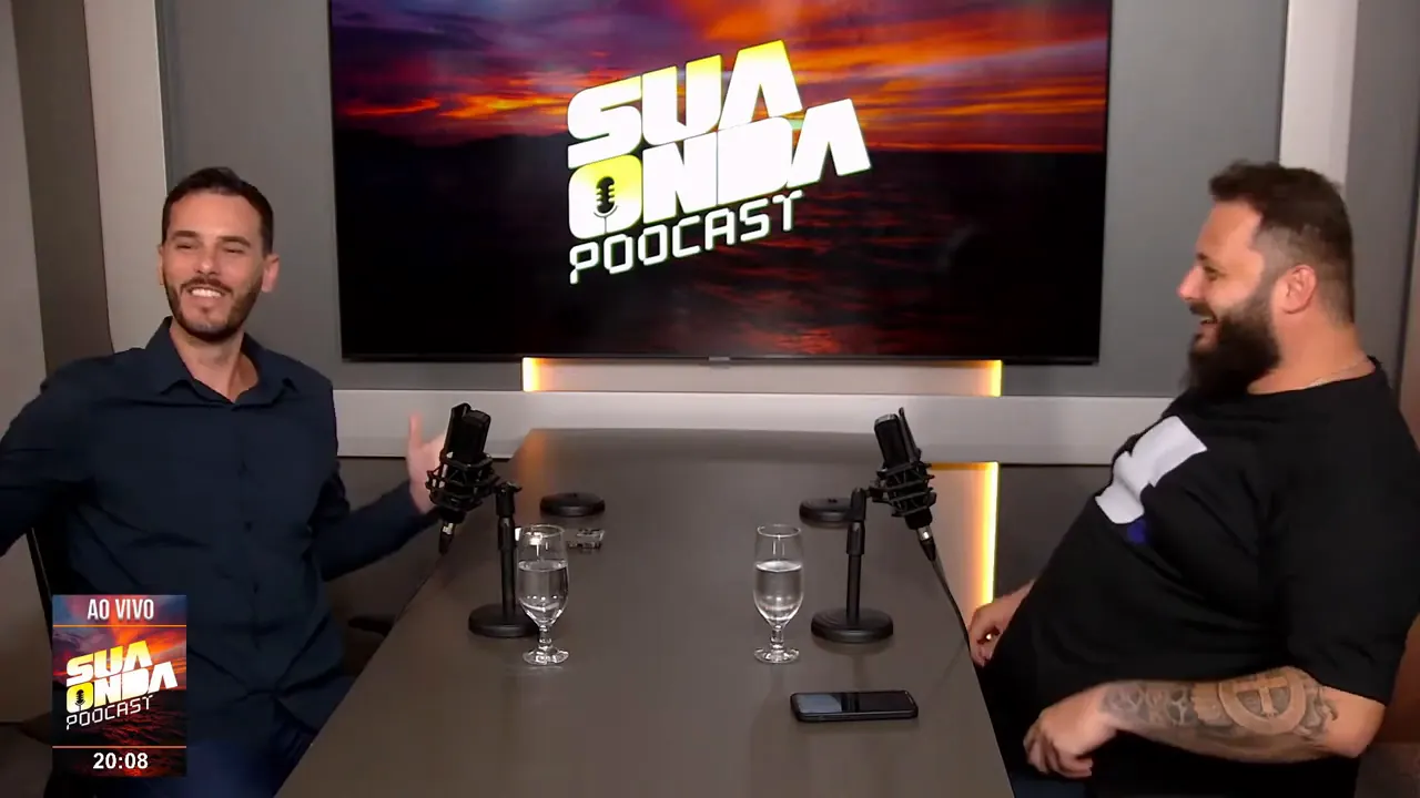 Alex Michels rindo com o convidado no estúdio do podcast Sua Onda